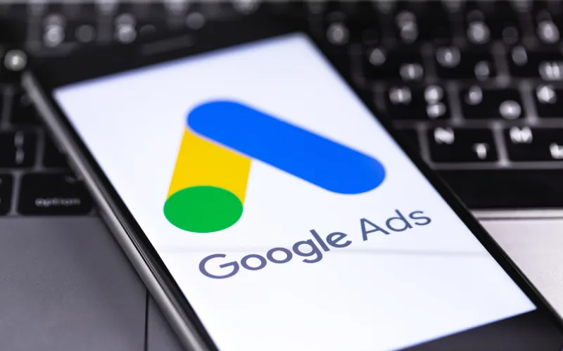 145095434_l A smartphone displaying the Google Ads logo on a keyboard background. The logo features colorful geometric shapes.