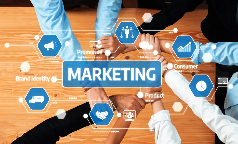 252871537_l Aerial view of a group of people forming a circle with their hands, overlaid with a digital graphic of various marketing terms and icons.